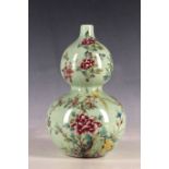 A Chinese double gourd vase, green field, decorated with flowering tree and birds, inscription and