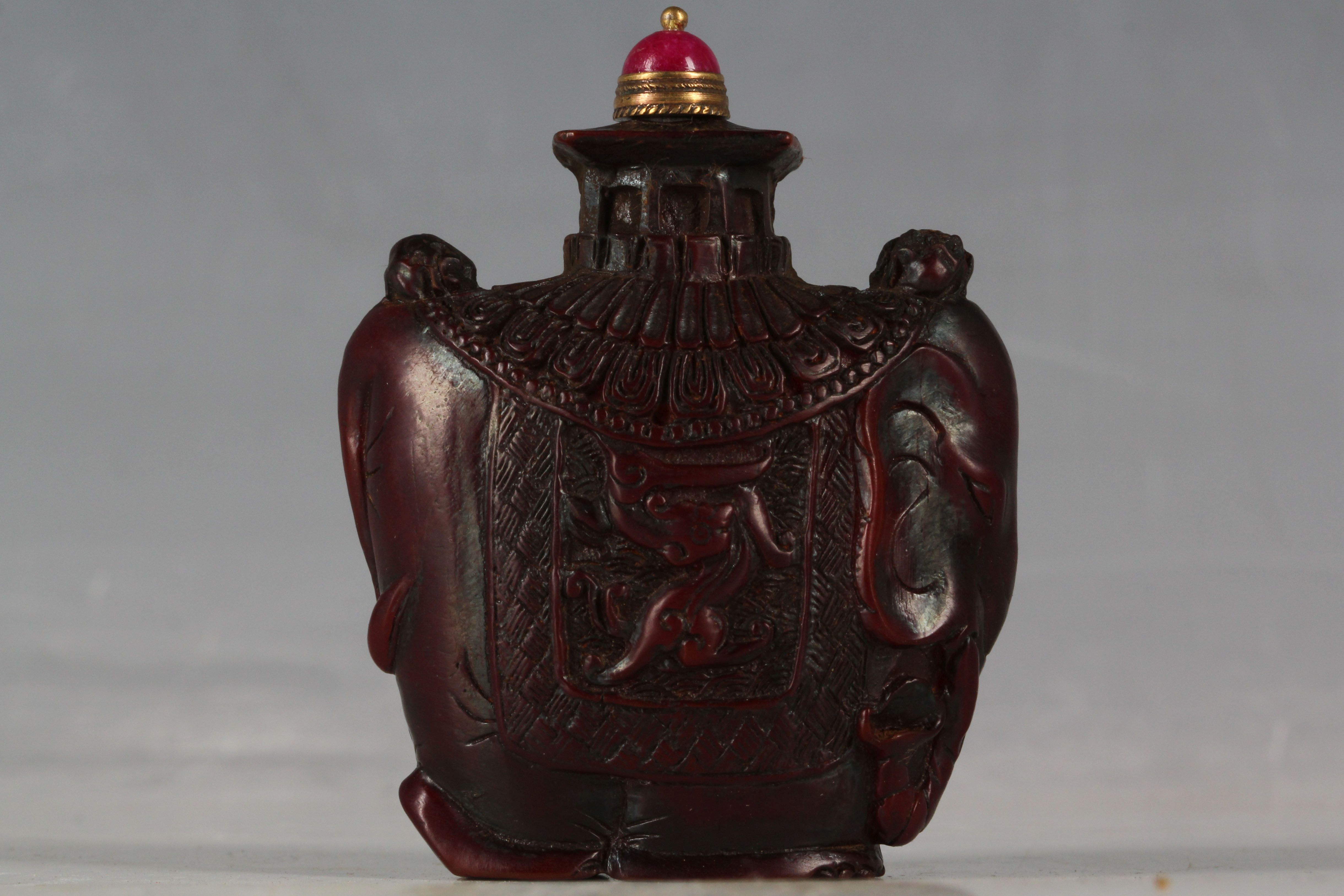 A Chinese snuff bottle, carved in the form of an elephant with howdah and banner of dragons, 7cm H.