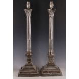 An early 20th Century pair of Corinthian column shaped, silver plated lamp bases, raised on