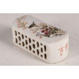 A Chinese paperweight, white glaze, study of a bird in flowering tree and shrubs, inscription,