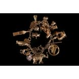 A 9ct gold charm bracelet, with many charms, including penguin, poodle, etc. (one loose charm) (