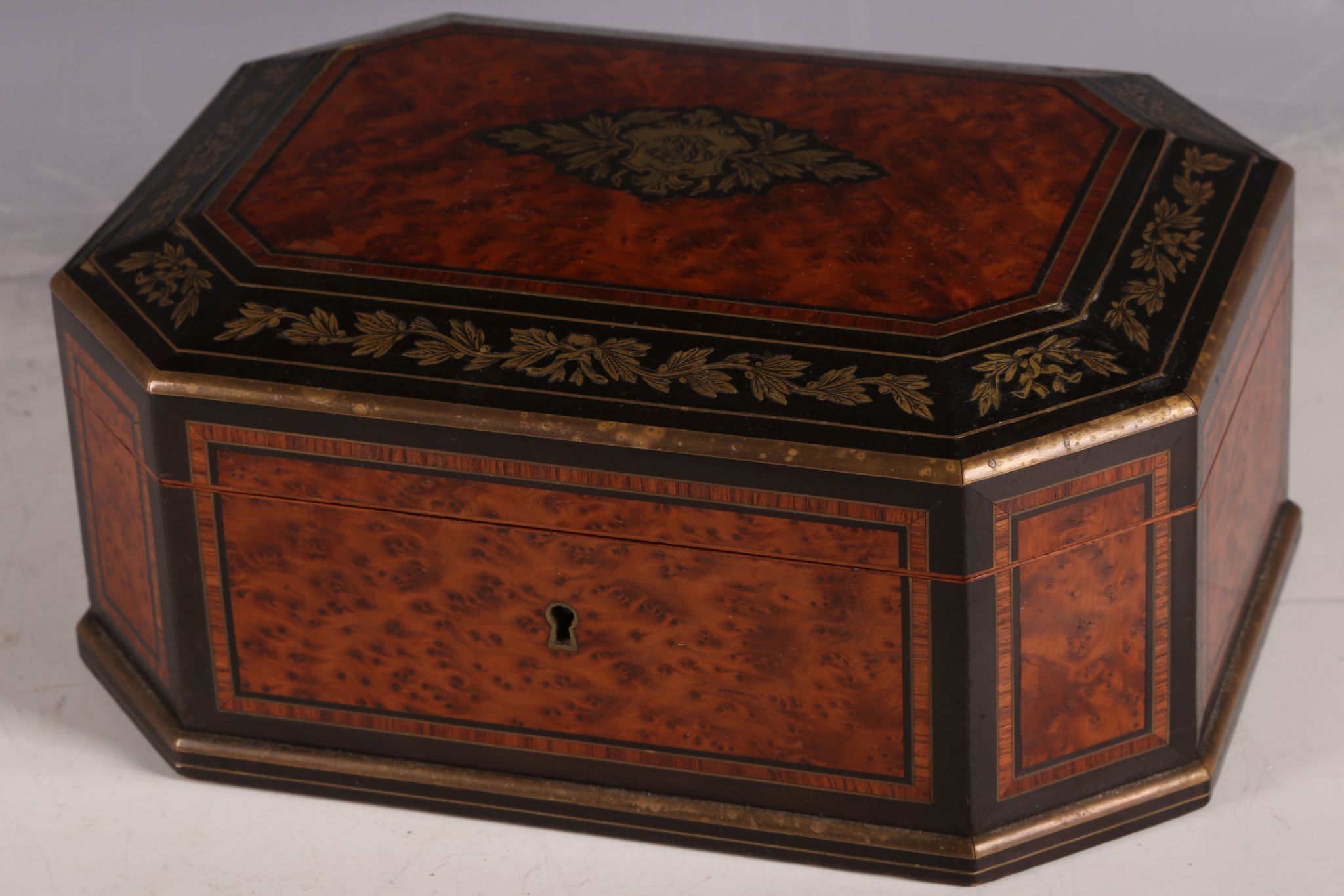 A 19th Century amboyna casket, with ebonised and gilt metal inlaid border decoration, and blue