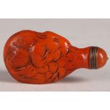 A Chinese orange glass snuff bottle, carved study of a rat with fruit, 7.5cm.