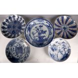 A group of five Japanese blue and white plates, one decorated with a scholar in a landscape and