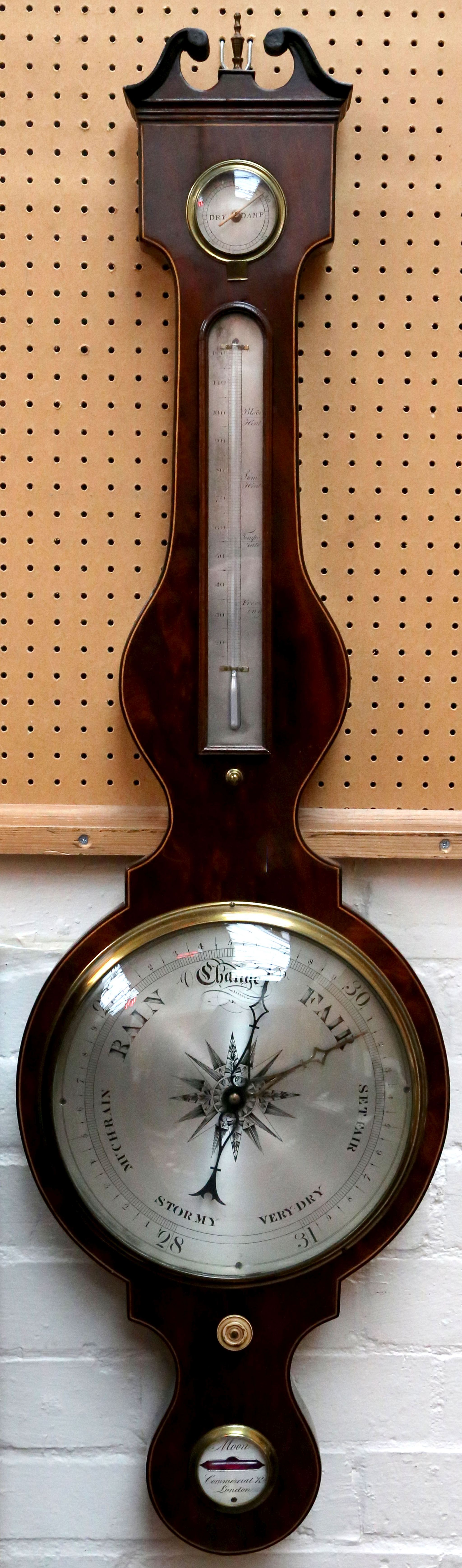 A Moon, Commercial Road London mahogany wheel barometer, with swan neck pediment above a silver dial