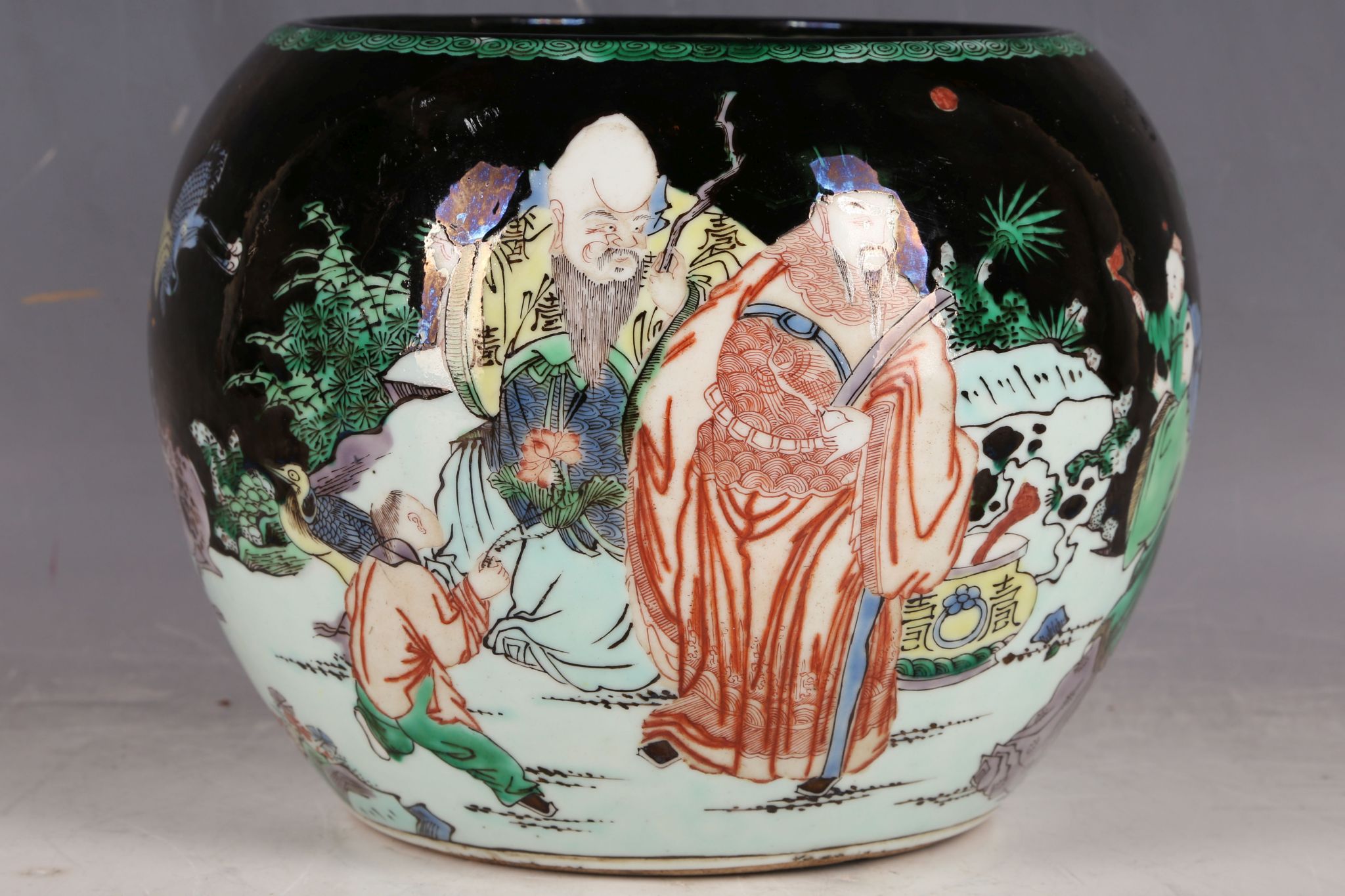 A Chinese famille noire globular vase, decorated with scholars, children, cranes and deer in a