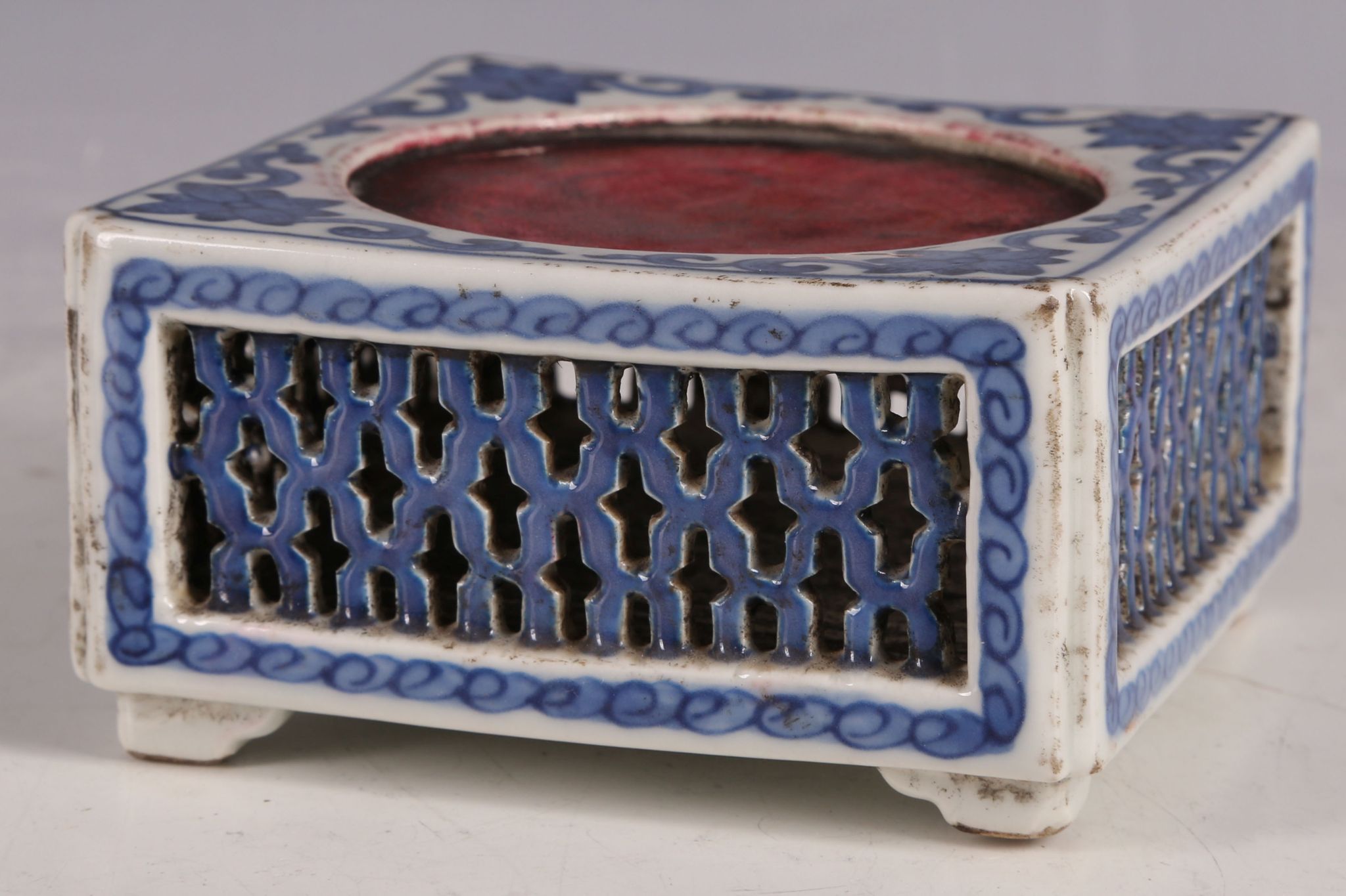 A Chinese ceramic ink mixing palette, blue glaze, trailing floral decoration, pierced panels,