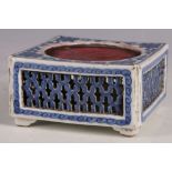 A Chinese ceramic ink mixing palette, blue glaze, trailing floral decoration, pierced panels,