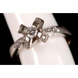 An 18ct white gold and diamond set ring, with cross-crown top over pierced shoulders.