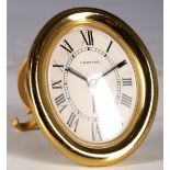 A circa 1980s gold plated Cartier oval strut clock.