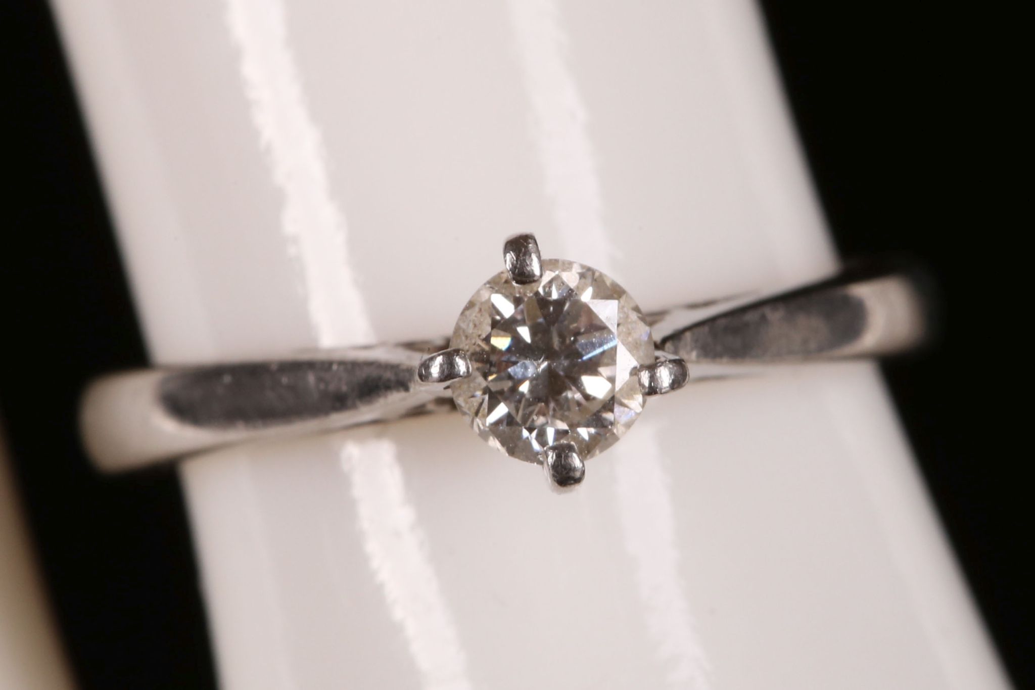 A platinum and diamond solitaire ring.