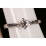 A platinum and diamond solitaire ring.