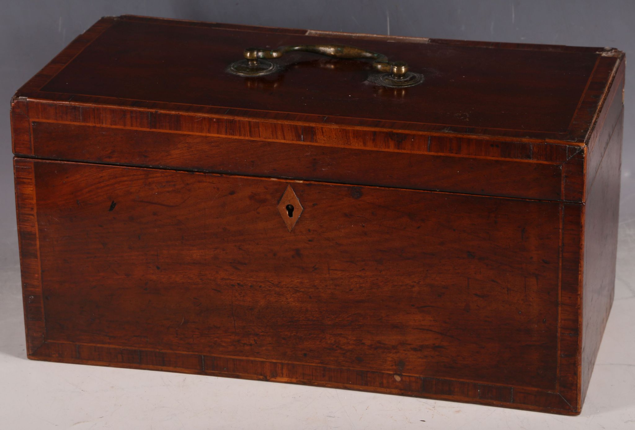 A 19th Century mahogany and crossbanded tea caddy, the hinged lid opening to reveal a blue and white