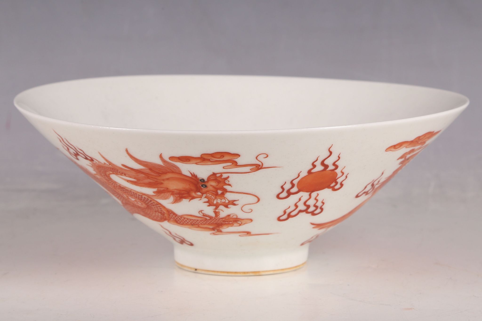 A Chinese 20th Century porcelain pedestal flared bowl, painted outside in iron red glazes with a