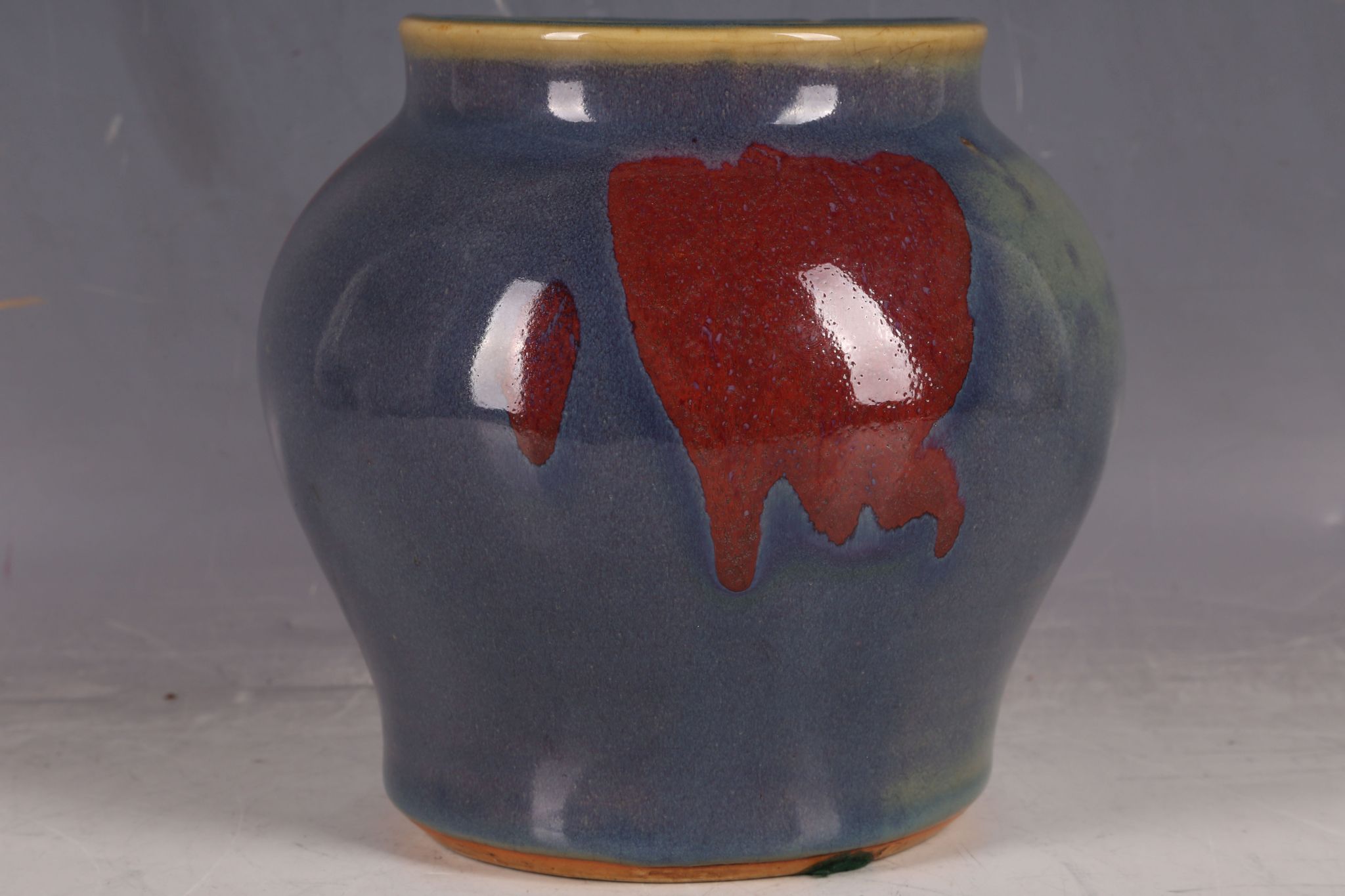 A Chinese flambé glazed wide shouldered vase, with red steaks in the glaze, 17cm H.