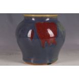 A Chinese flambé glazed wide shouldered vase, with red steaks in the glaze, 17cm H.
