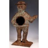 An iron clock case (possibly American), depicting a hatted banjo player, 41cm H.