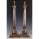 A pair of mid 20th Century, Corinthian column shaped, silver plated lamp bases, raised on stepped