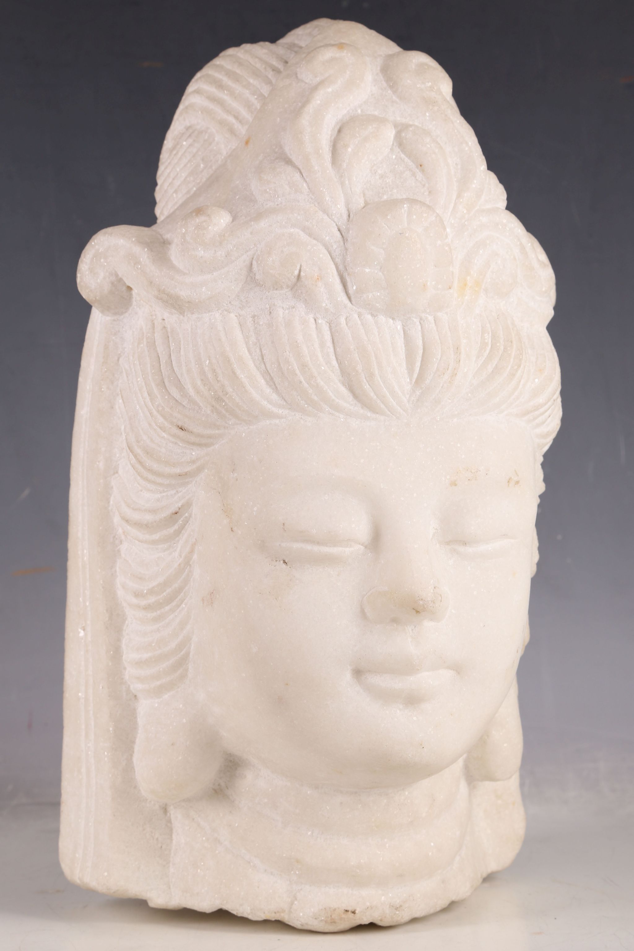 After the Antique, white granite carved head of a Cambodian Buddha.