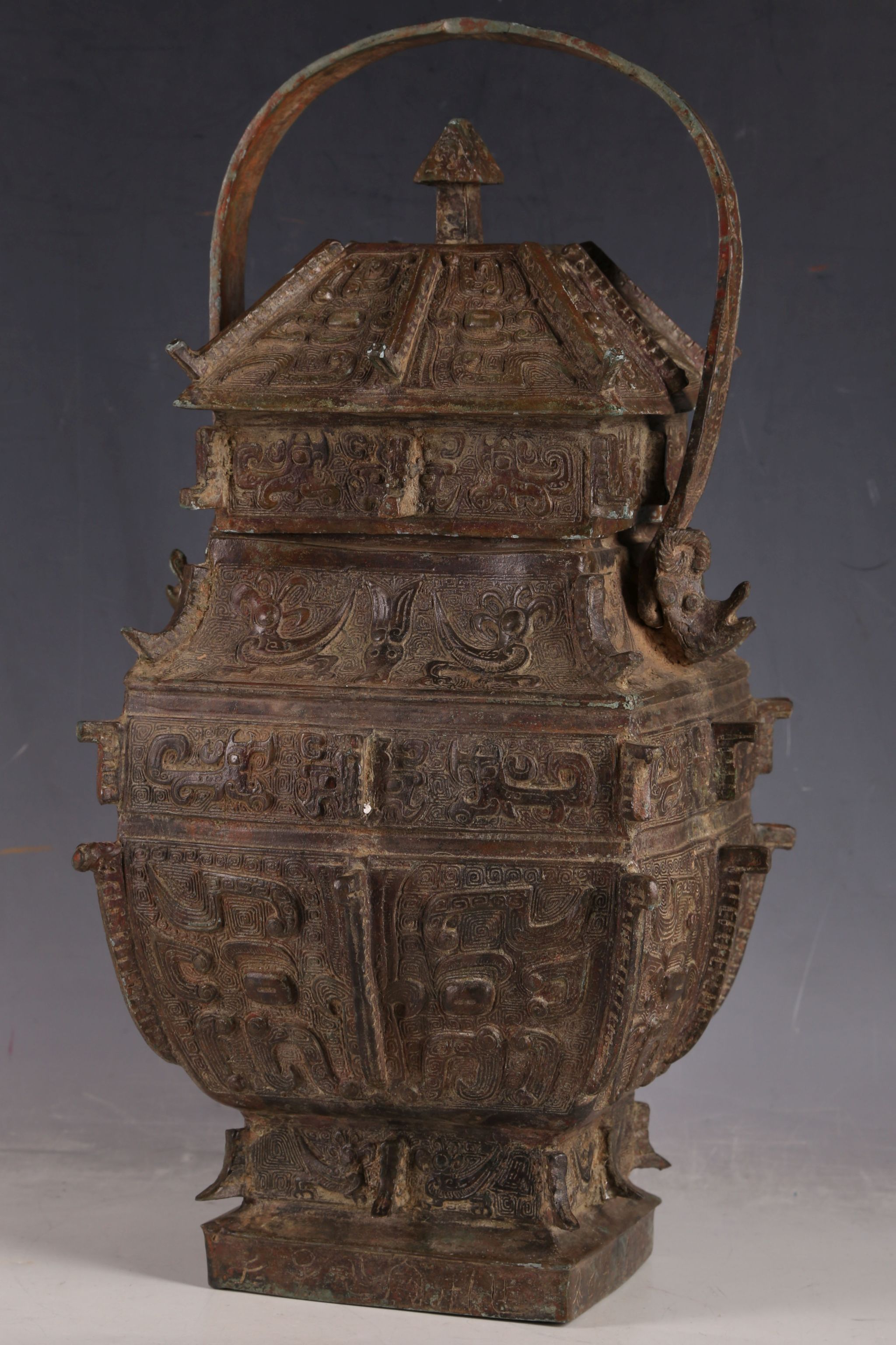 A Chinese archaic form bronze jar of temple design, scrolls and temple dogs to lid, insects to