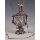 An Indian white metal ladies table top scent dispenser, bird surmount, two figures around urn with