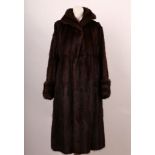 A vintage dark brown Musquosh ladies fur coat by Marshall & Snelgrove, London, with large collar,