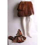 A tribal leather and woven hat and a raffeta skirt. (2)