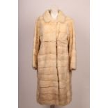 A vintage, pearl white, straight style mink coat, knee length, horizontal pelts, patch pockets,