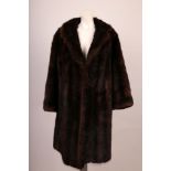 A vintage, dark brown musquash knee length fur coat, with collar, full sleeves, side pockets,