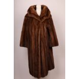 A 1950s full length film star style brown mink coat and matching mink and velvet pill box hat in