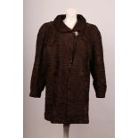 A 1940s brown Astrakhan three quarter length coat, with Peter Pan collar, large square button detail