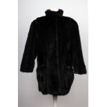 A vintage, black mink three quarter length ladies jacket, with leather shoulder and pocket top