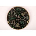 A Chinese nine dragon famille noire circular plaque. Qing Dynasty, Kangxi period. A central five