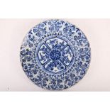 A large blue and white dish. China, Kangxi. Vividly painted with a central flower medallion with