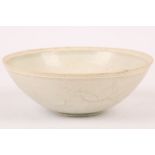 A Chinese qingbai glazed bowl. Song Dynasty. The exterior incised with floral decoration, sitting on