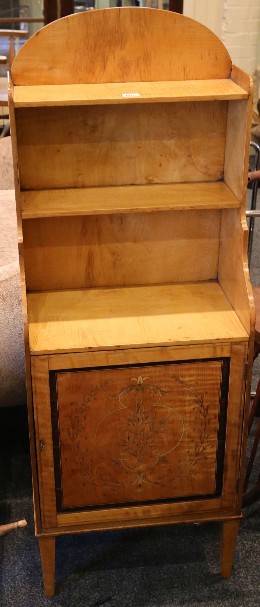 An early 19th Century satinwood waterfall bookcase, arch top with two shelves over cupboard, door