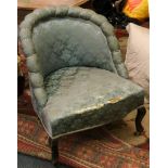 An Edwardian damask upholstered tub chair, raised on cabriole legs.