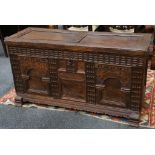 A 17th Century oak coffer, the hinged lid enclosing a candle box over a carved front, raised on