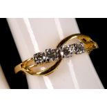 An 18ct gold and diamond four stone cross-over ring.