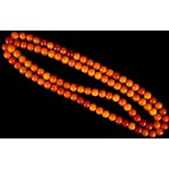 A necklace, amber colour, consisting of many spherical drilled beads.