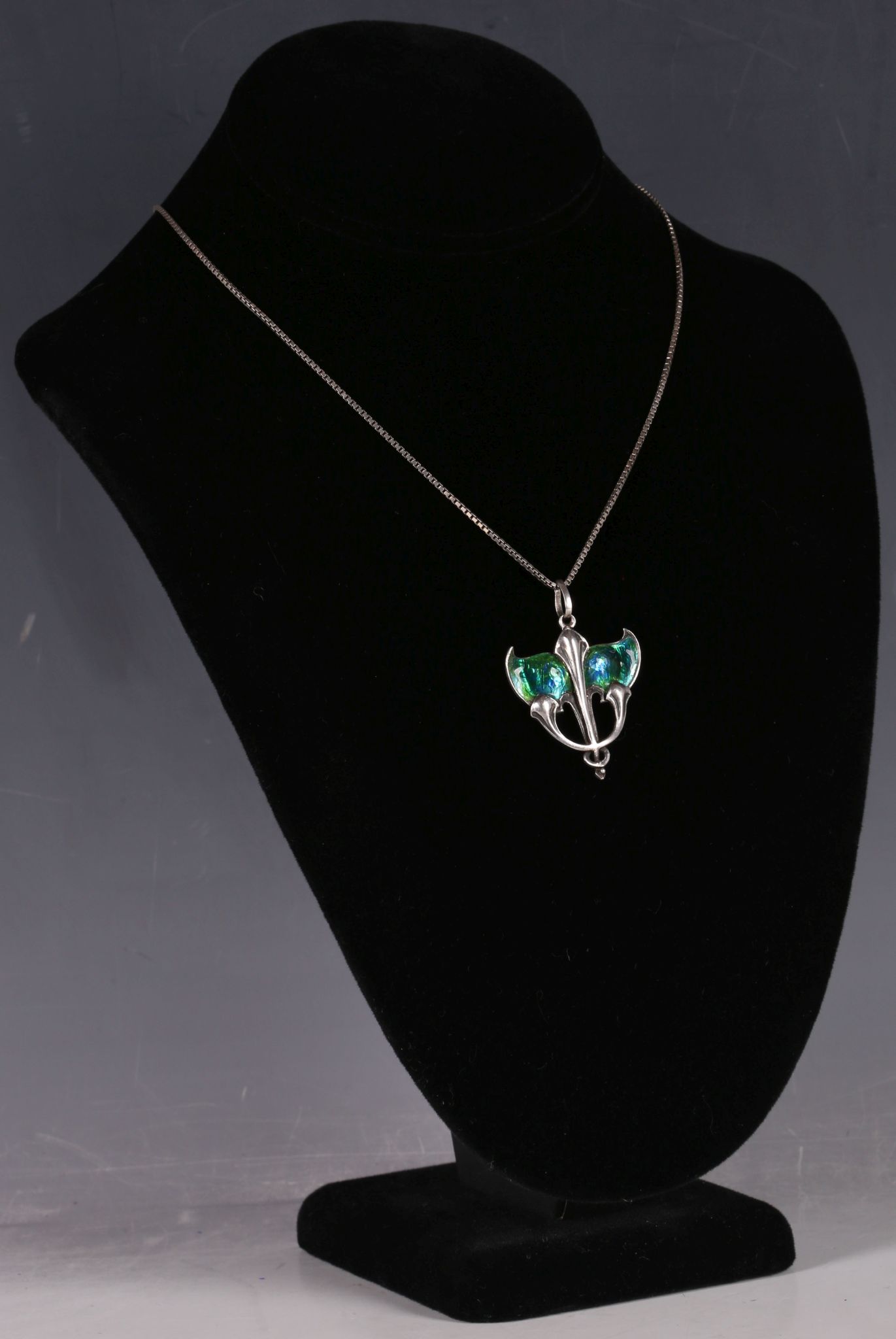 An Art Nouveau silver and enamelled pendant on chain.