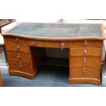 A 19th Century serpentine kneehole desk in satinwood, with boxwood inlay and green leather writing