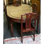 An Oriental hardwood oval dining table and six chairs, faux bamboo effect back and legs with