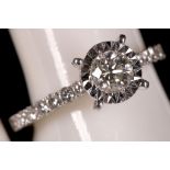 An 18ct white gold and diamond solitaire ring, with diamond shoulders, 0.86pts total.