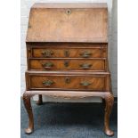 A walnut and crossbanded bureau, the fall front enclosing drawers and pigeonholes over three