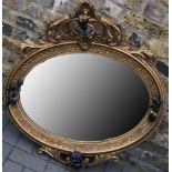 A French style oval mirror, bronzed effect maiden surmount with winged cherubs to flanks, applied