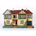 A 1950s Tri-ang Stock Brokers dolls house, with side garage, front opening to reveal four rooms