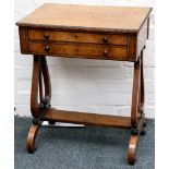 A ladies Georgian walnut work table, having two drawers and supported on lyre form ends, terminating