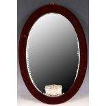 An early 20th Century Venetian oval shaped small size corner wall mirror.