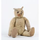 A 1920s English blonde mohair Teddy bear, with painted back glass eyes, black embroidered nose,